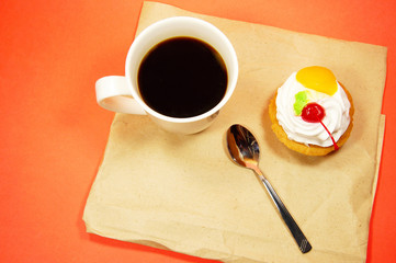 cup of coffee and fruit cake on a paper