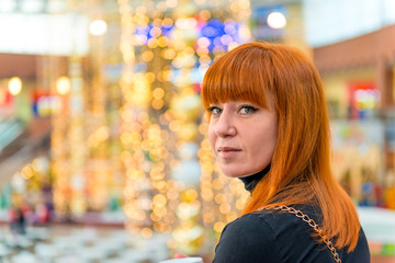 Fototapeta premium portrait of a girl with red hair in the mall
