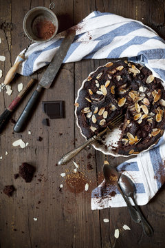 dark chocolate and almonds cake on wooden table