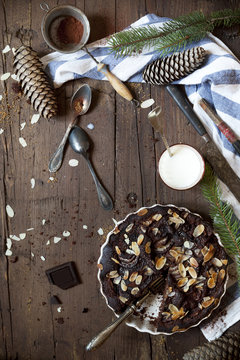 dark chocolate and almonds cake on table with pine branches