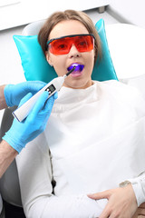 Utwardzanie plomby światłoczułej, kobieta u dentysty