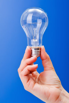 Hand holding a clear incandescent light bulb