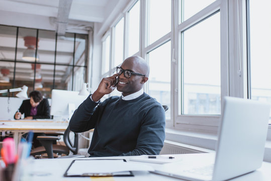 Young Man Talking On His Mobile Phone In Office