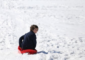 Fototapeta na wymiar Child plays with bob in the snow in winter