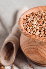 buckwheat in a wooden bowl on white background