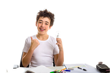 Fototapeta na wymiar Boy holds a lightbulb while doing homework