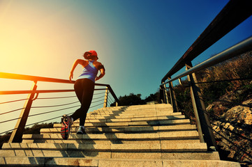 young fitness woman running on seaside stone stairs