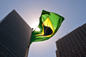 Fotobehang Brazilië Braziliaanse nationale vlag tegen wolkenkrabbers bij zonsondergang