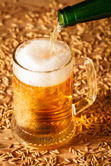 Pouring beer from a bottle into a glass on a wooden table