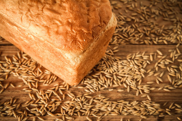 Bread and wheat on an old wooden table. Close up