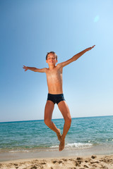 Fototapeta na wymiar Boy jumps on the beach