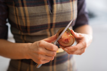 Closeup on young housewife cutting cherokee purple tomato