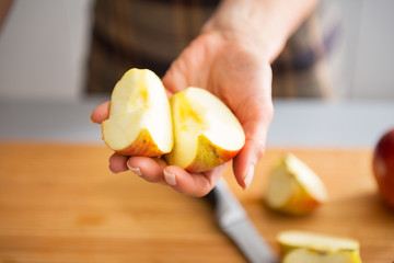 Closeup on young housewife showing apple slices