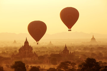 air balloons over Buddhist temples at sunrise. Bagan, Myanmar.