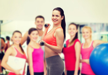 young sporty woman with light dumbbells