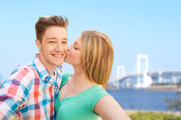 couple kissing and taking selfie over bridge