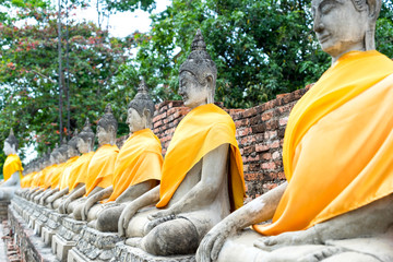Old historic cement buddha statues along temple corridor