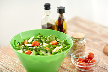 close up of salad bowl and spices on kitchen table