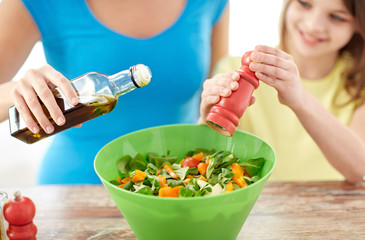close up of happy family cooking salad in kitchen