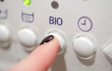 close up of woman finger pressing washer button