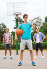 Obraz premium group of smiling teenagers playing basketball