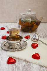 tea in a glass with a coaster and candies