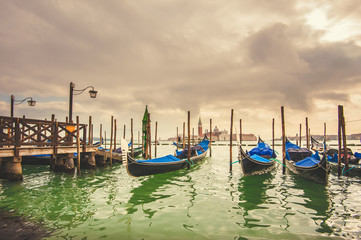 Gondolas docked to the poles on the Grand Canal in Venice.