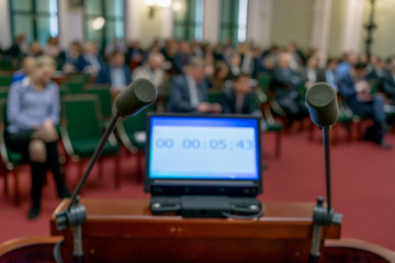 screen with time and two microphones in a conference room