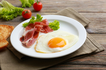 Bacon and eggs on rustic wooden planks background