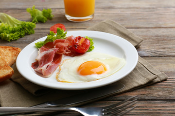 Bacon and eggs on rustic wooden planks background