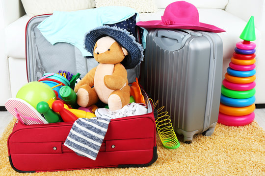 Suitcases packed with clothes and child toys