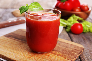Glass of tomato juice with vegetables on wooden table close up