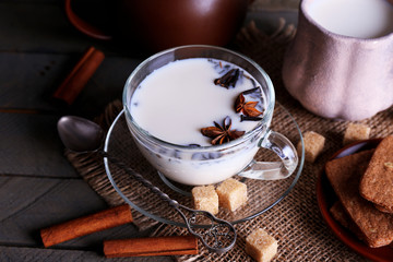 Black tea with milk in cups and teapot with lump sugar