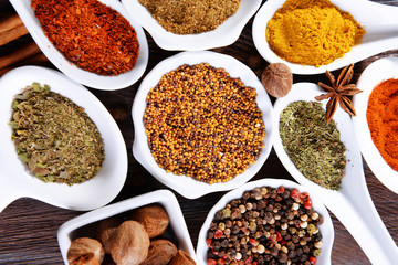 Different kinds of spices in ceramics spoons, close-up,