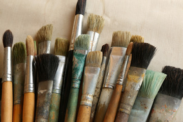 Fototapeta premium Different paintbrushes on fabric background