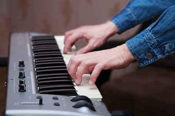 hands of the musician on the keyboard synthesizer closeup