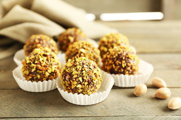 Tasty homemade pistachio candies on wooden table