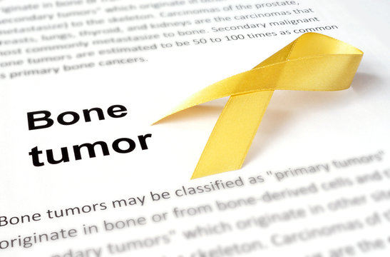 Paper with bone tumor and yellow ribbon.