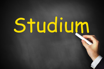 Hand schreibt studium auf schwarze Tafel