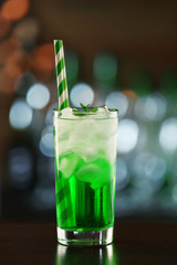 Green cocktail on table on dark background