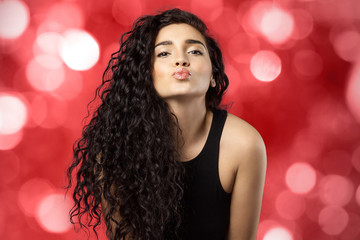 pretty woman with curly long hair gives a kiss