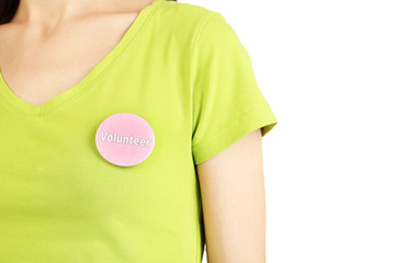 Round volunteer button on shirt of girl isolated on white