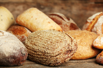 Different fresh bread on old wooden table