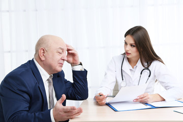 Young female doctor receiving patient in her office