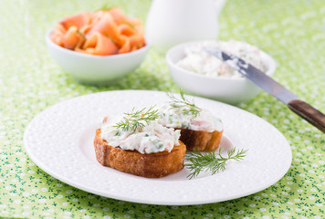 Canape with soft cheese spread on white plate