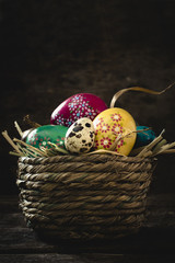 Easter eggs in basket on rustic wooden planks