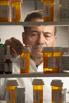 white male looking at assortment of prescription drugs