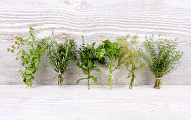 Italian herbs in bundle on white wooden