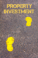 Yellow footsteps on sidewalk towards Property Investment message