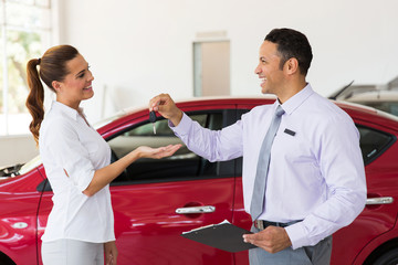 young woman receiving new car key